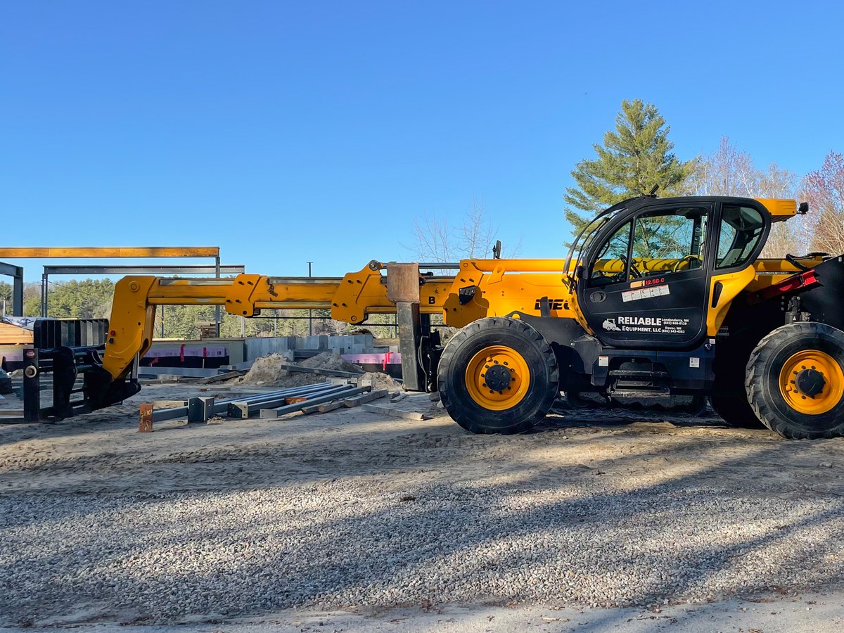 Yellow Dieci telescopic handler lifting steel beams on a construction site
