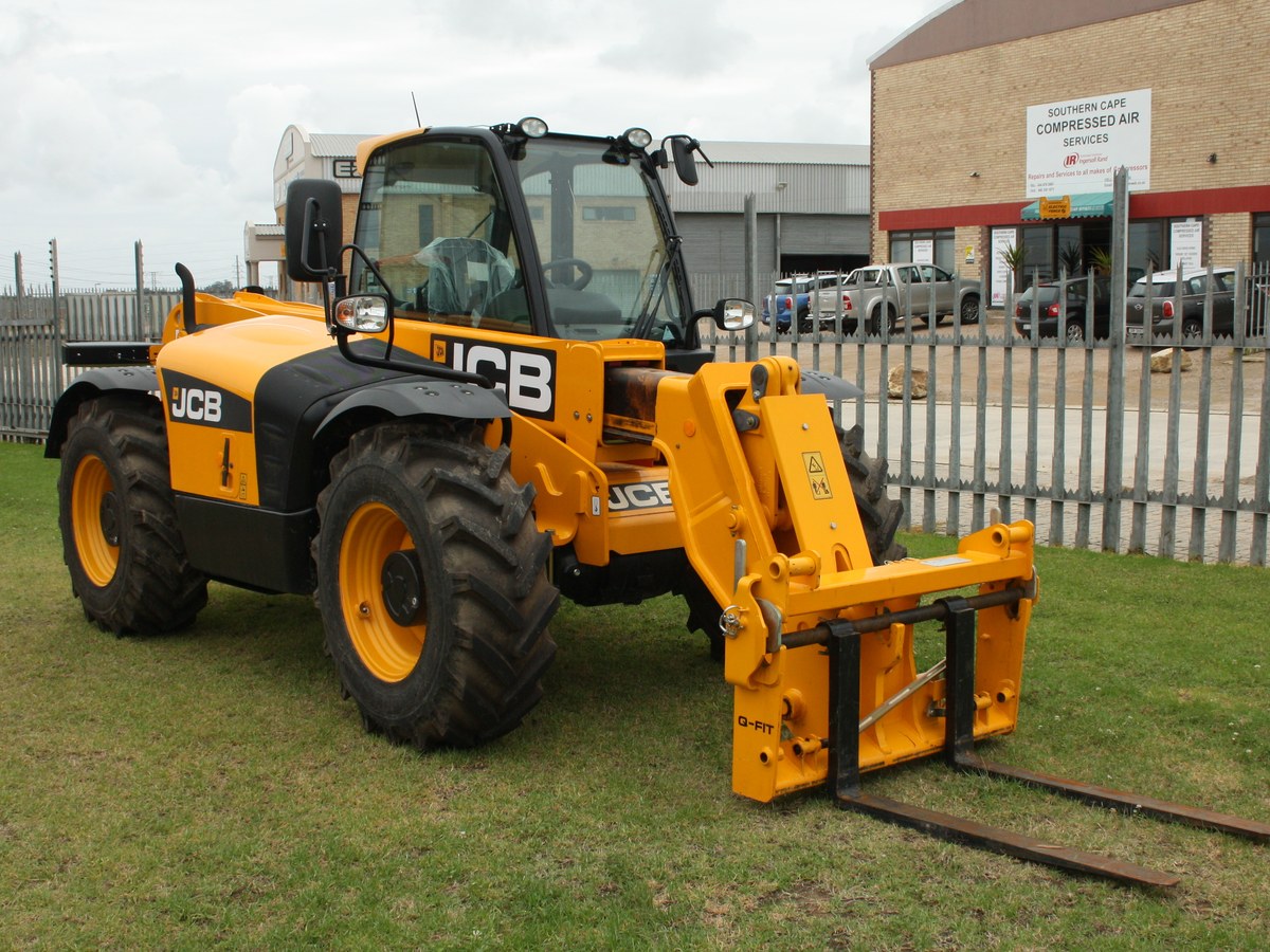 Yellow JCB 531-70 telescopic handler with pallet forks parked on grass